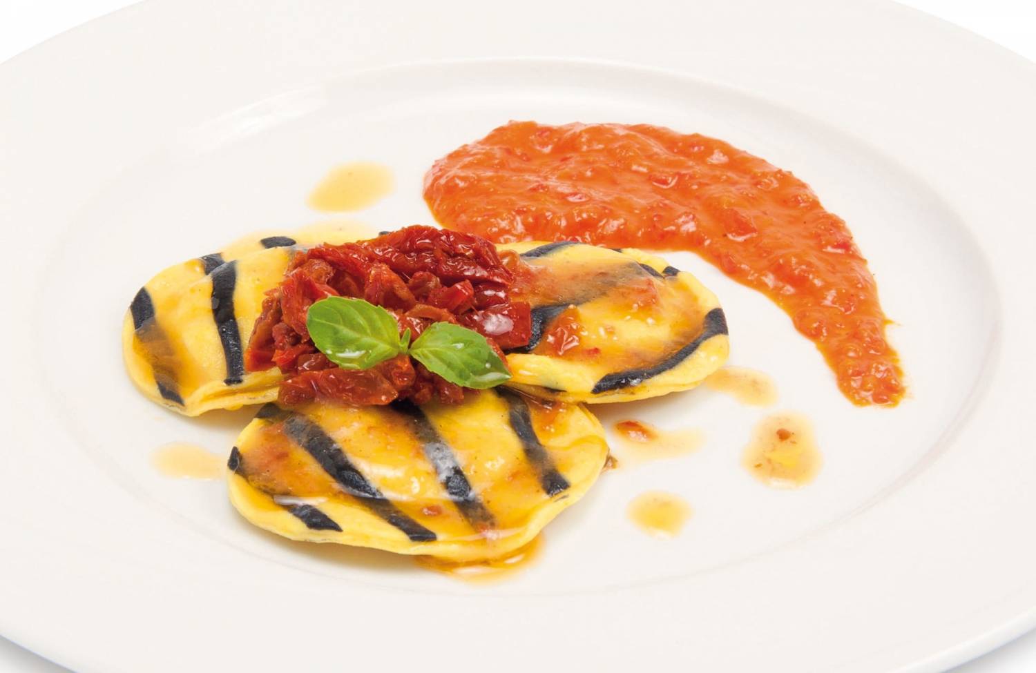 Ravioles de bacalao con crema de pimientos y tomates secos en trozos